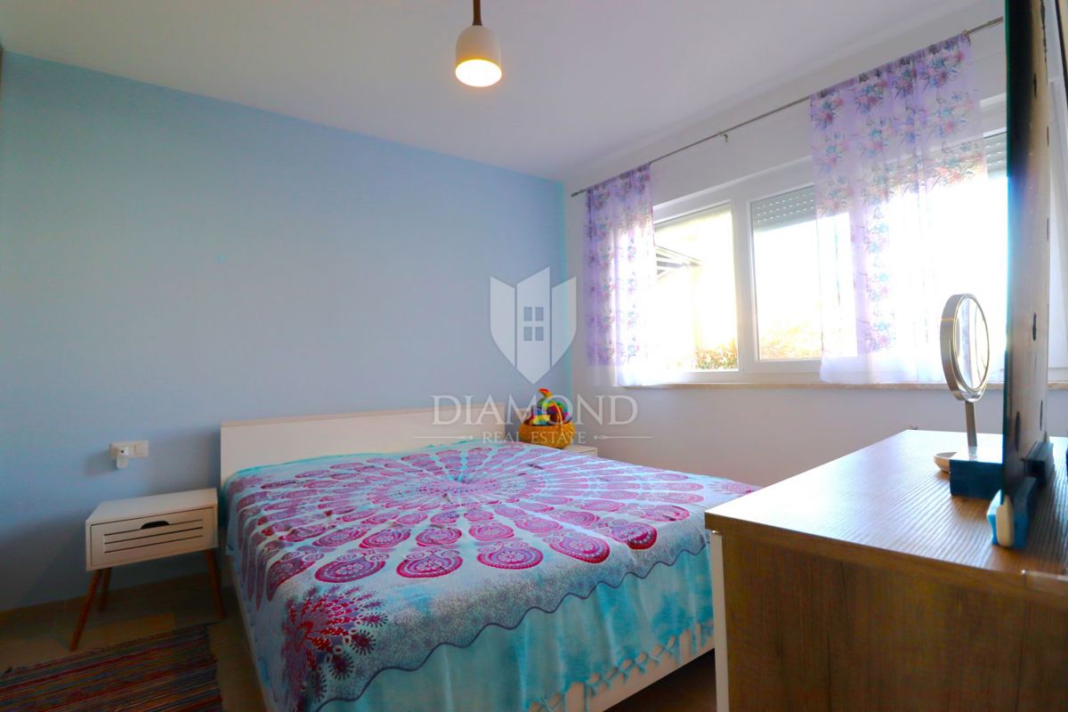 Stanovanje v pritličju s tremi sobami, zasebnim vrtom in parkirnim mestom, na odlični lokaciji v središču kraja, le nekaj minut od Poreča.