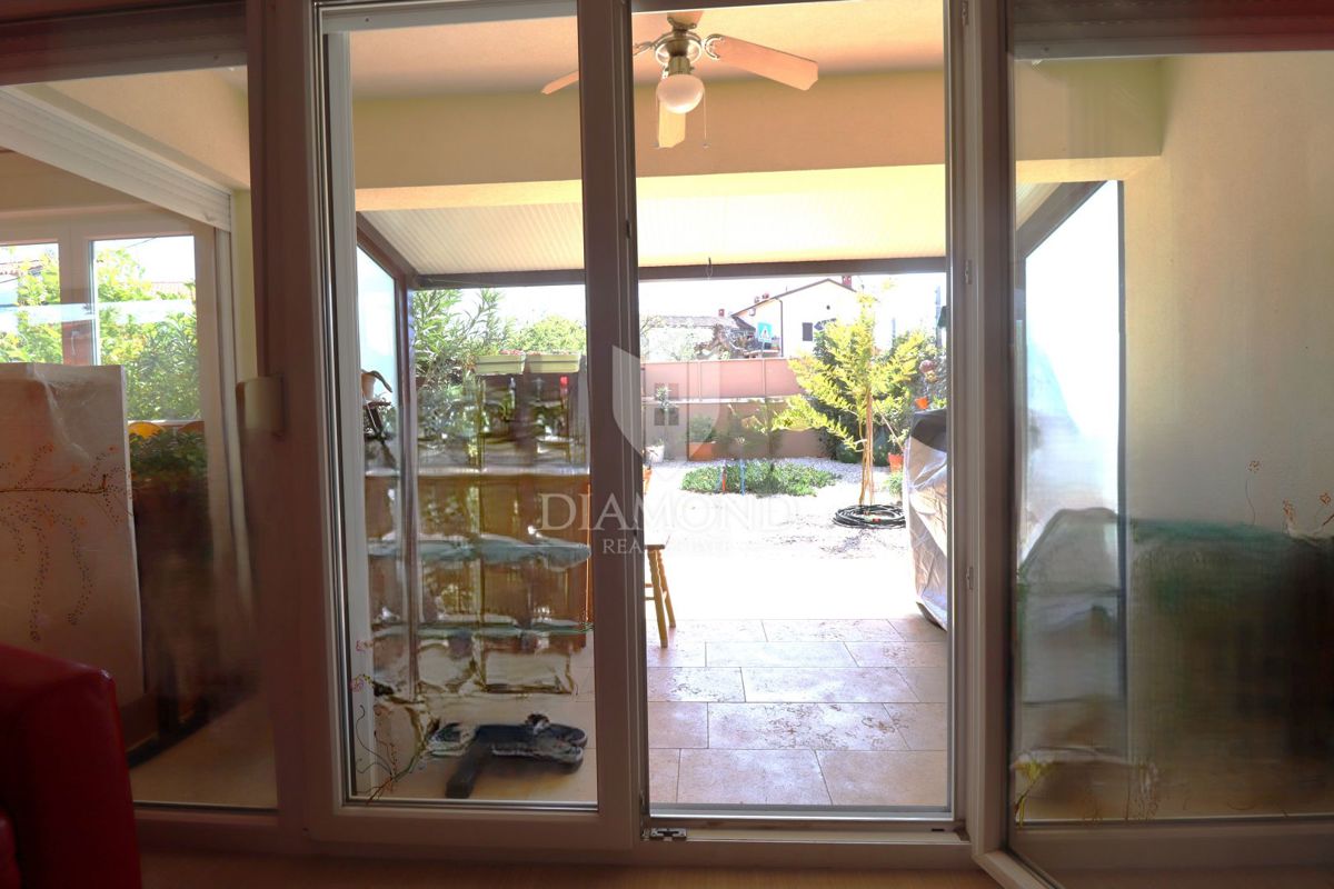 Stanovanje v pritličju s tremi sobami, zasebnim vrtom in parkirnim mestom, na odlični lokaciji v središču kraja, le nekaj minut od Poreča.