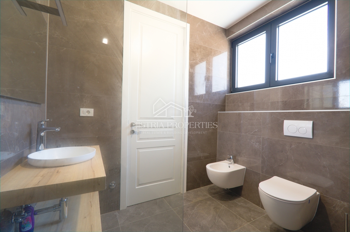 Opremljeno stanovanje v moderni novogradnji z dvoriščem 500m od plaže