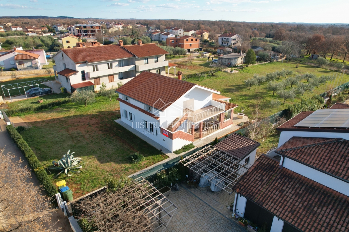 Hiša z oljčnim nasadom na prostornem gradbenem zemljišču in prenovljeno stanovanje z veliko potenciala