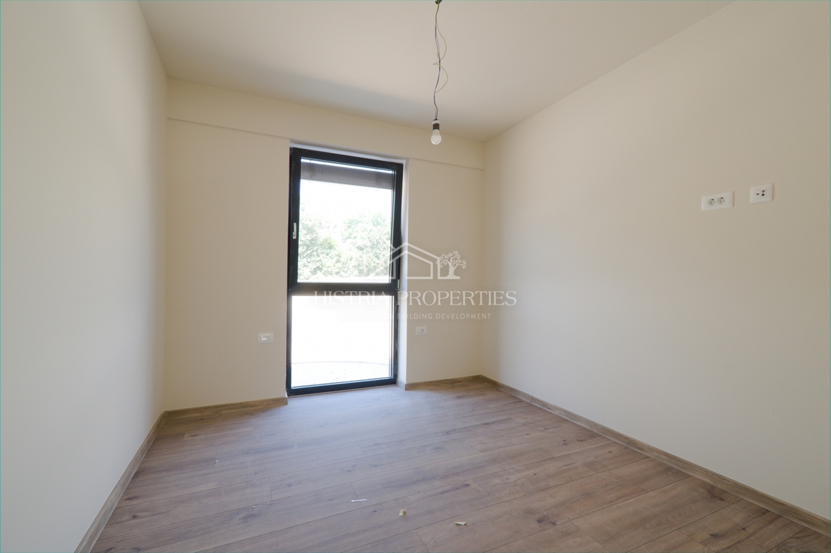 Pritlično stanovanje s skupnim bazenom v luksuzni novogradnji