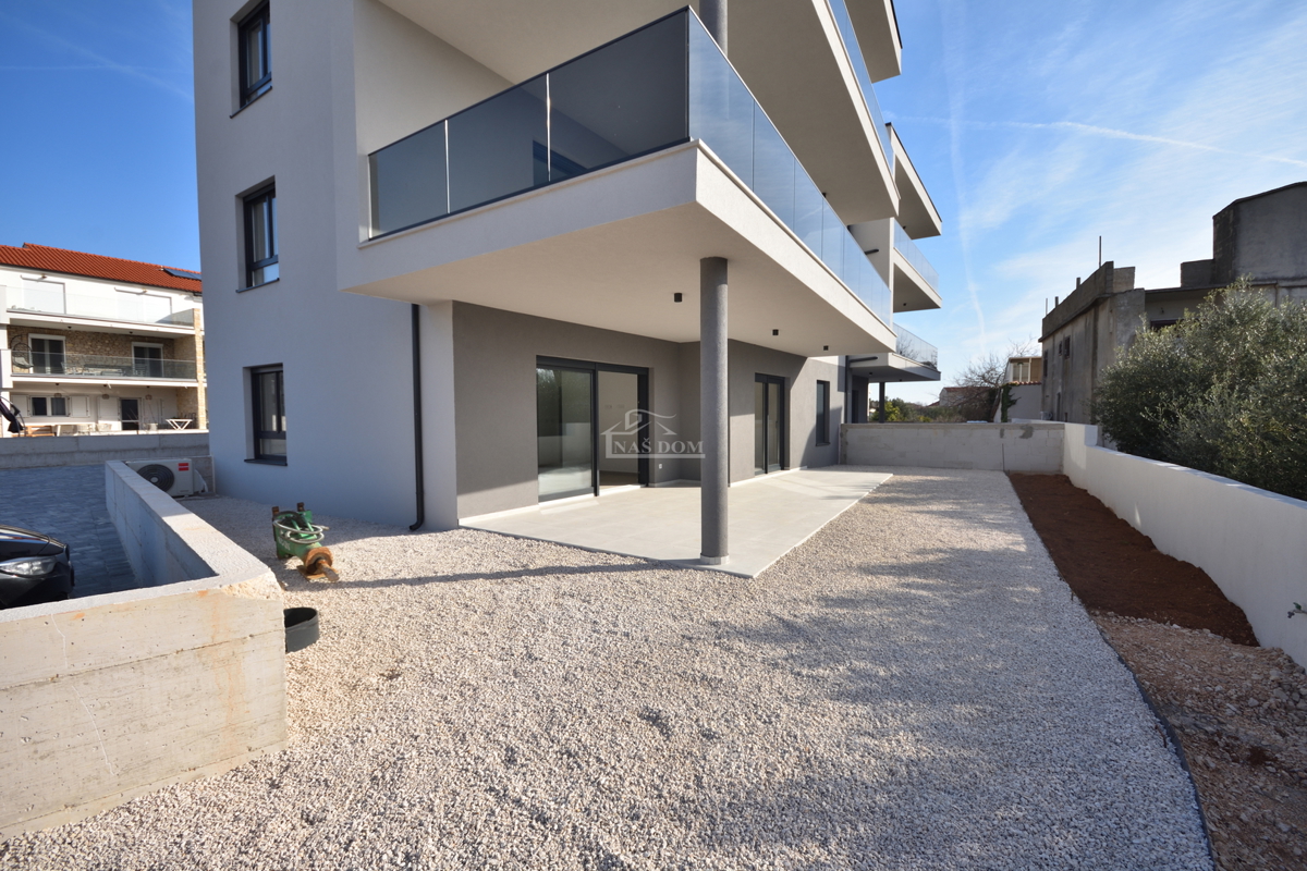 Luksuzno dvoprostorsko stanovanje S1 z veliko zemljiščem v Tribunju – 250 m od morja