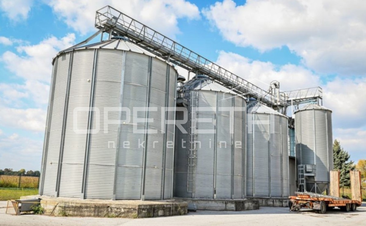 Poslovni kompleks na lokaciji med Varaždinom in Ludbregom: hala, skladišče, silosi in poslovna stavba.