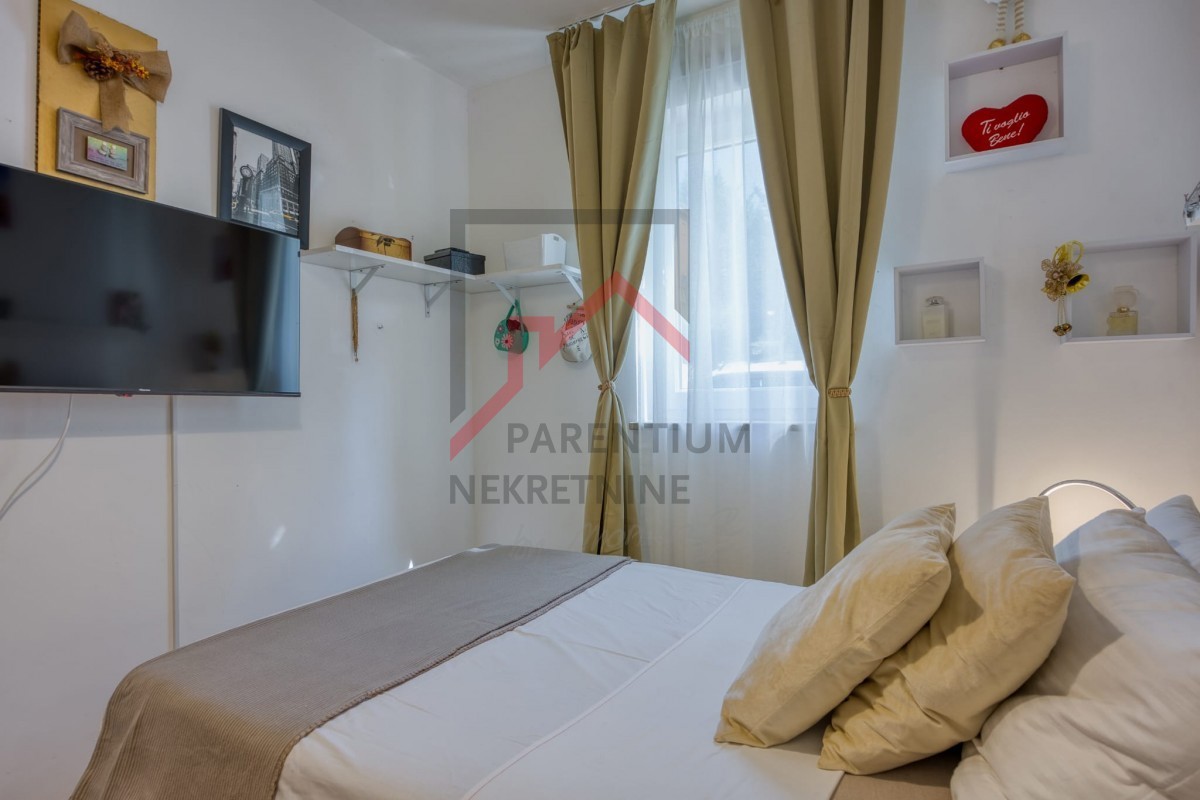 Pritlično stanovanje z dvoriščem, dvema spalnicama in opremljeno